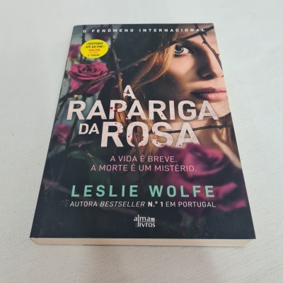 Capa do livro 'A Rapariga da Rosa' com rosas e rosto de mulher, texto em branco e turquesa