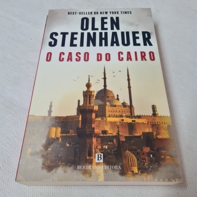 Capa do livro 'O Caso do Cairo' de Olen Steinhauer com imagem de mesquitas ao pôr do sol