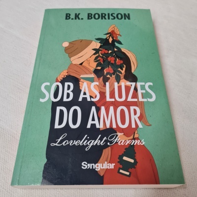 Livro Sob as Luzes do Amor, capa verde com ilustração de casal e texto
