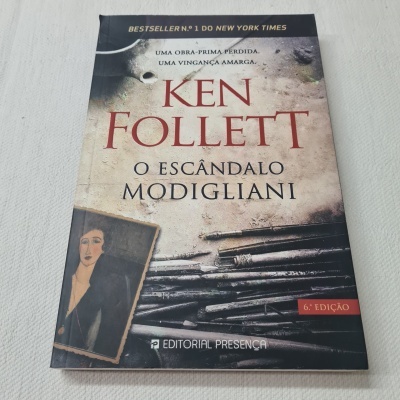 Capa do livro 'O Escândalo Modigliani' de Ken Follett com pintura e ferramentas de pintura.