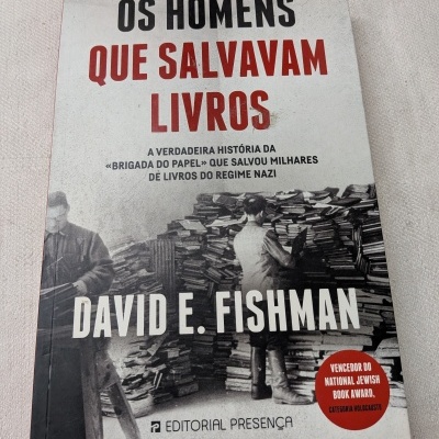 Capa do livro Os Homens Que Salvavam Livros de David E. Fishman com imagem a preto e branco de pessoas e livros e selo vermelho