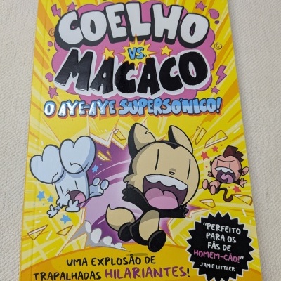 Livro com capa amarela e personagens animados de coelho, cão e macaco em fundo animado