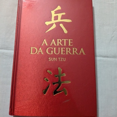 Livro capa rígida vermelha com texto dourado