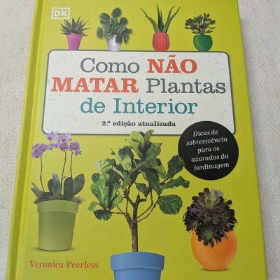 Capa de livro amarelo com imagens de vasos com plantas e texto em português sobre cuidados de plantas de interior