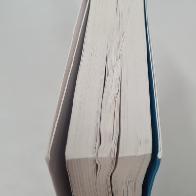 Livro com capa dura azul e páginas brancas onduladas