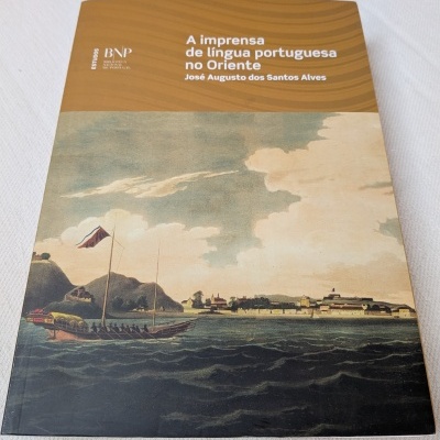 Livro sobre imprensa portuguesa no Oriente com ilustração de barco e costa antiga