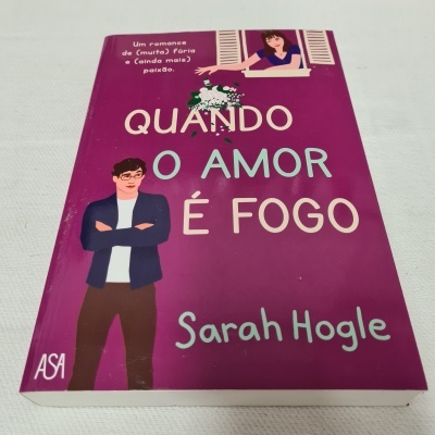 Livro 'Quando o amor é fogo' com capa roxa, ilustrações de homem e mulher, texto promocional e selo ASA