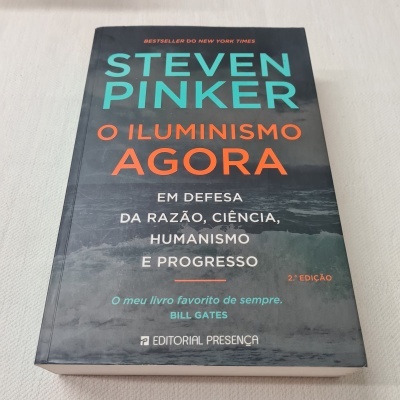 Capa de livro 'O Iluminismo Agora' de Steven Pinker com texto colorido e imagem de ondas do mar.