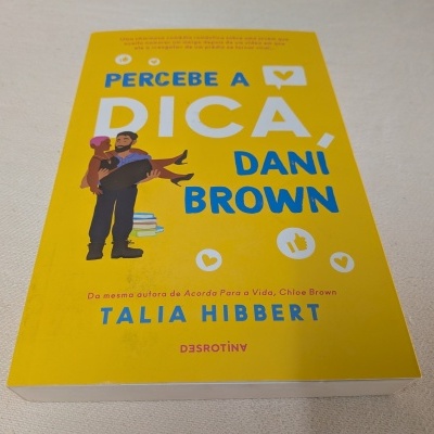 Livro Percebe a Dica Dani Brown capa amarela com ilustração e texto em azul e branco