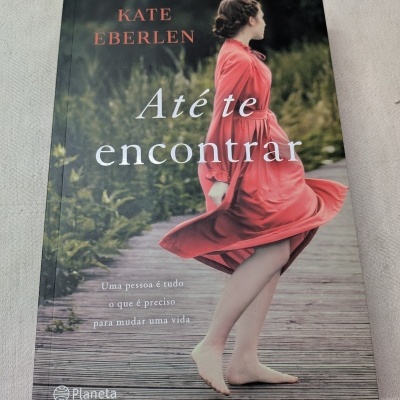 Capa do livro Até te encontrar de Kate Eberlen mostrando mulher com vestido vermelho descalça numa passadeira de madeira