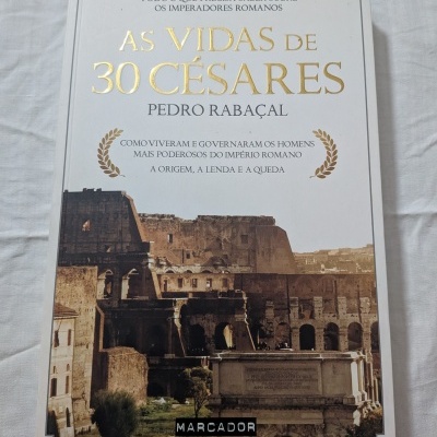 Livro com capa branca com título dourado e foto do Coliseu romano