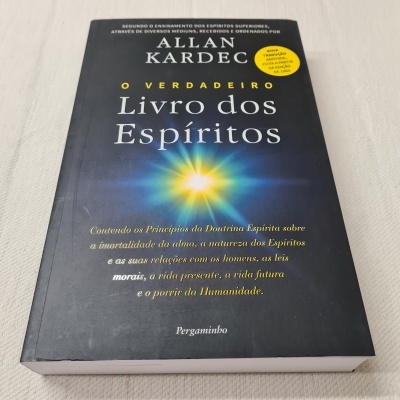 Livro 'O Verdadeiro Livro dos Espíritos' de Allan Kardec, capa preta com luz ao centro e texto branco e amarelo