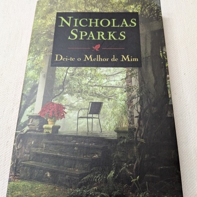 Livro Nicholas Sparks Dei-te o Melhor de Mim com capa ilustrada de jardim e cadeira