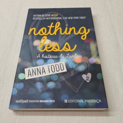 Livro 'Nothing Less: A história de Landon' de Anna Todd com capa azul e luzes desfocadas