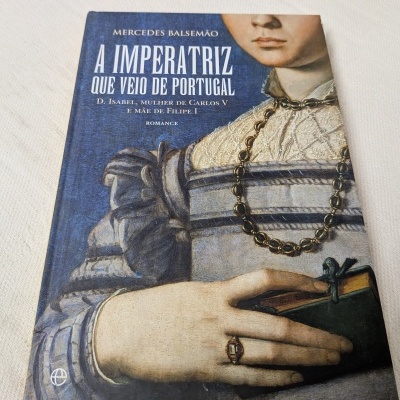 Capa de livro A IMPERATRIZ QUE VEIO DE PORTUGAL com pintura de mulher antiga em roupa renascentista e acessório de joias.