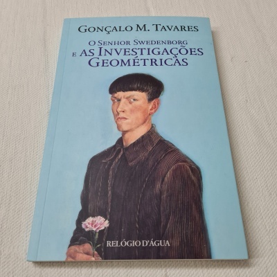 Livro com capa azul claro mostrando retrato de homem e texto do título e autor
