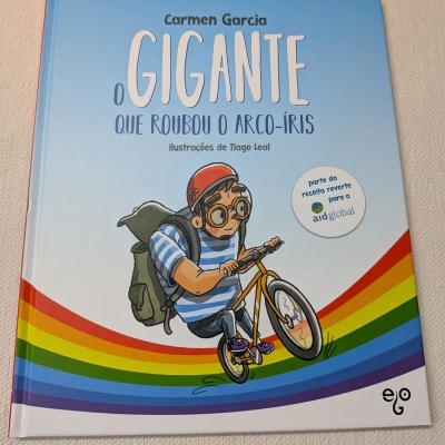 Capa de livro infantil com arco-íris e menino de bicicleta