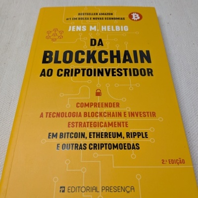 Livro amarelo Da Blockchain ao Criptoinvestidor com texto em preto e vermelho