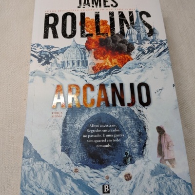 Capa do livro ARCANJO de James Rollins com explosão, montanhas nevadas, crânios e uma pessoa com casaco rosa.