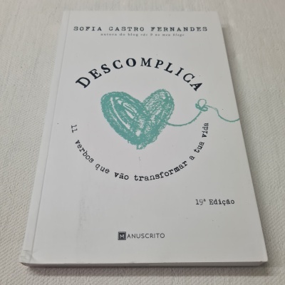 Capa de livro branca com título Descomplica e coração verde desenhado