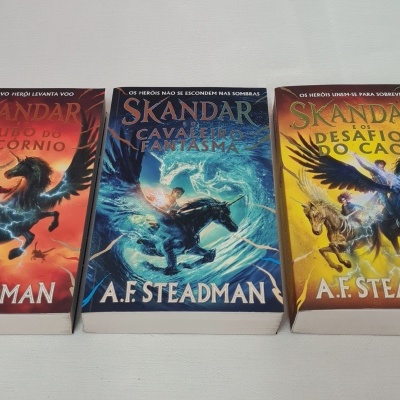 Três livros da série Skandar de A.F. Steadman com capas ilustradas coloridas