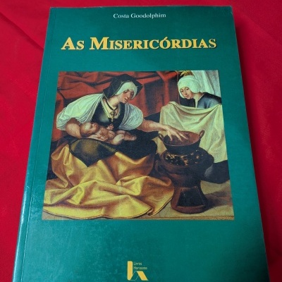 Livro As Misericórdias de Costa Goodolphim com capa verde e ilustração antiga.