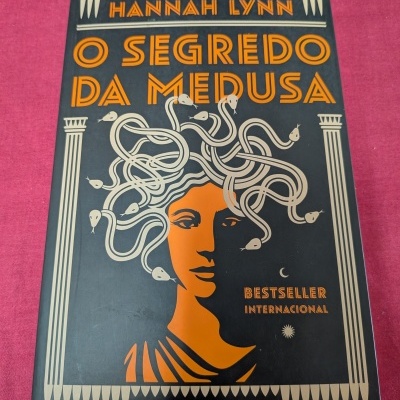 Capa de livro O Segredo da Medusa de Hannah Lynn com design em preto, laranja e branco.