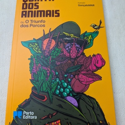 Livro amarelo com título Quinta dos Animais e ilustração colorida de porco e elementos naturais
