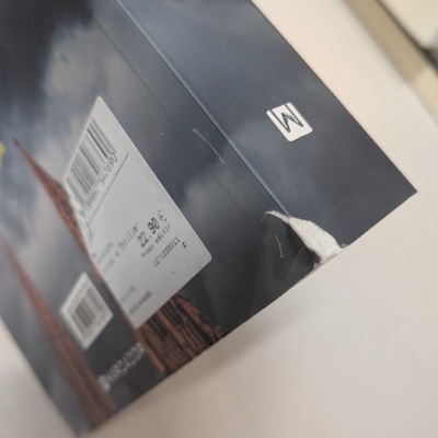 Capa de livro preta com etiqueta de preço e código de barras.