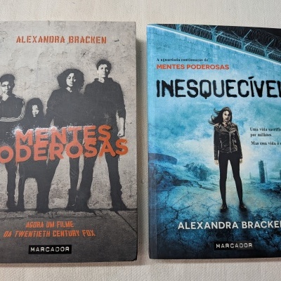 Dois livros de Alexandra Bracken nas cores cinzento e azul sobre tecido claro