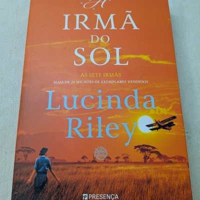Capa de livro laranja com texto e ilustração de pôr do sol