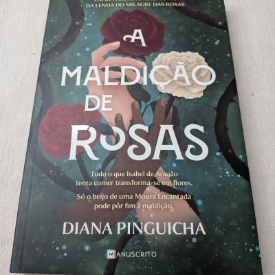 Capa do livro A Maldição de Rosas com rosas vermelha e branca e mãos entrelaçadas