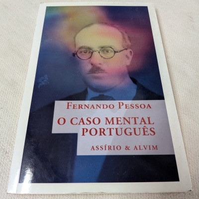 Livro O CASO MENTAL PORTUGUÊS de Fernando Pessoa sobre tecido branco