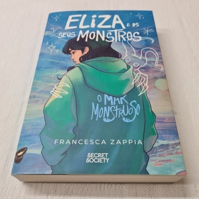 Capa do livro 'Eliza e os seus monstros O Mar Monstruoso' com personagem desenhada e texto visível.