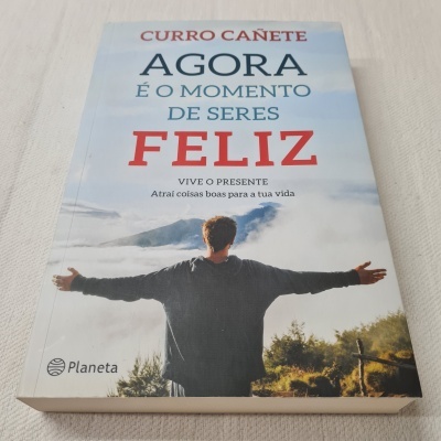 Capa de livro com pessoa de costas braços abertos na natureza e texto motivacional