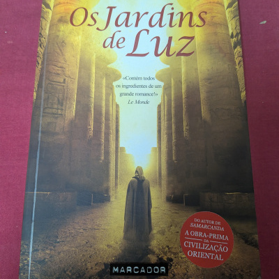 Capa do livro Os Jardins de Luz com pessoa a caminhar entre colunas antigas