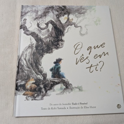 Livro ilustrado com título em português e desenho de árvore e criança