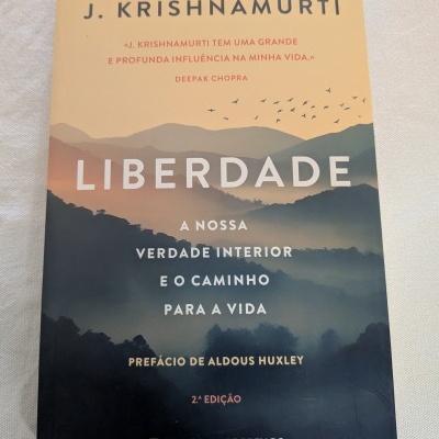 Capa de livro LIBERDADE de J. Krishnamurti com montanhas e pássaros em fundo vazio.