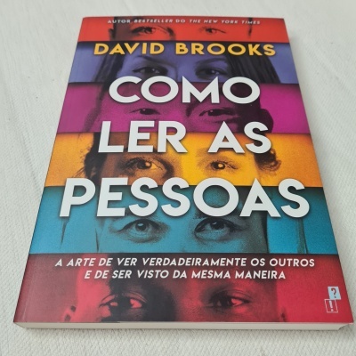 Capa do livro 'Como Ler as Pessoas' de David Brooks com várias faixas coloridas e olhos de pessoas