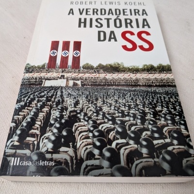 Capa do livro A VERDADEIRA HISTÓRIA DA SS com imagem de soldados e bandeiras nazis