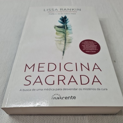 Capa de livro Medicina Sagrada com pena colorida sobre fundo branco
