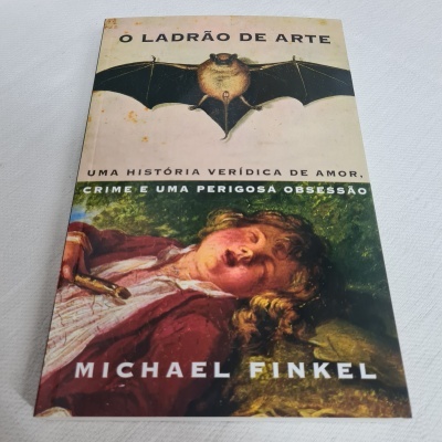 Capa de livro com morcego e pintura de rapaz adormecido, texto em português