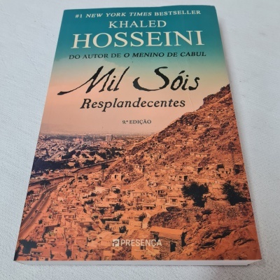 Capa do livro Mil Sóis Resplandecentes de Khaled Hosseini com paisagem de cidade
