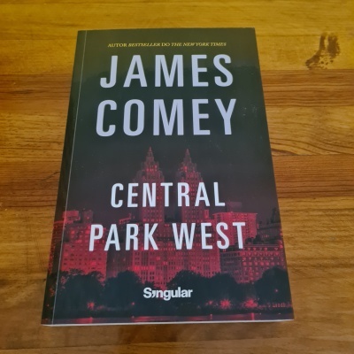 Livro 'Central Park West' de James Comey com capa preta e vermelha sobre superfície de madeira