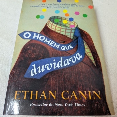Livro O Homem Que Duvidava de Ethan Canin com capa ilustrada e texto em português