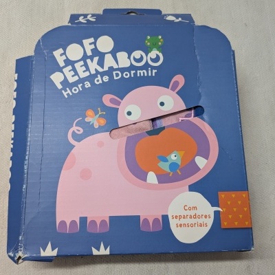 Embalagem azul com hipopótamo cor-de-rosa e texto em português.