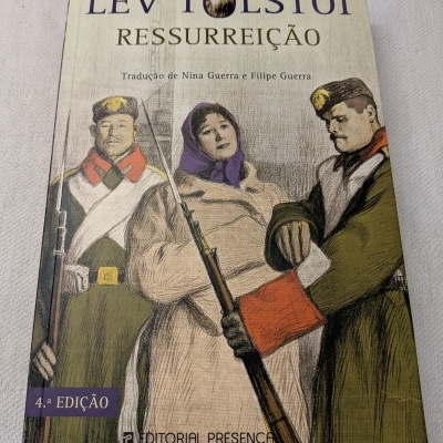 Capa do livro Ressurreição de Lev Tolstói com ilustração de duas figuras masculinas em uniforme militar e uma mulher no meio com lenço roxo.