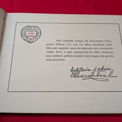 Página de livro com texto em português, selo em forma de coração e assinatura manuscrita.