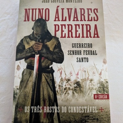 Livro Nuno Álvares Pereira com imagem de cavaleiro medieval e texto sobre fundo claro