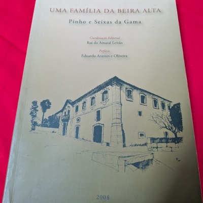 Capa de livro bege com ilustração de edifício antigo e texto em azul e vermelho